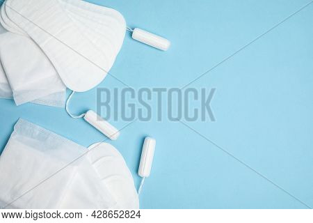 Menstrual Pads, Tampons And Pantyliners On Light Blue Background, Flat Lay. Space For Text