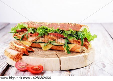 Fresh Baguette Sandwiches With Chicken, Cheese, Tomatoes And Fresh Salad, On Wooden Cutting Board On