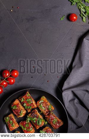 Flat Lay With Ready To Eat Cabbage Rolls In Tomato Sauce And Chopped Parsley On Black Skillet Pan, C