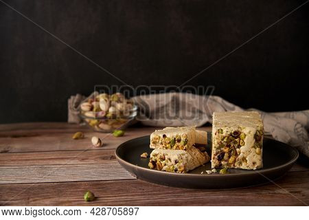 Organic Halva With Pistachios On A Wooden Surface. Traditional Middle Eastern Sweets. Jewish, turkis