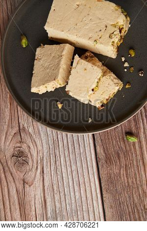 Organic Halva With Pistachios On A Wooden Surface. Traditional Middle Eastern Sweets. Jewish, turkis