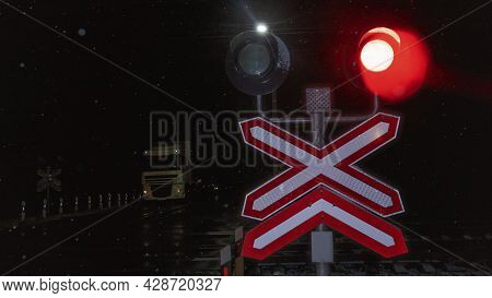 Train Crossing Gates Closed At Night. Train Grade Crossing With Blinking Or Flashing Lights While Tr