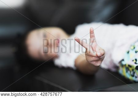 Selective Focus. Happy Blur Child Pointing Up Two Fingers. Asian Girl Pointing Number Two Fingers Si