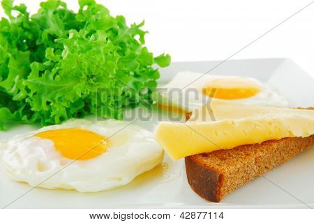 Spiegeleier und gold Käse auf weißen Teller