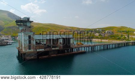 Abandoned Factory With Pier On Coast. Shot. Beautiful Pier With Abandoned Factory Building Or Fishin
