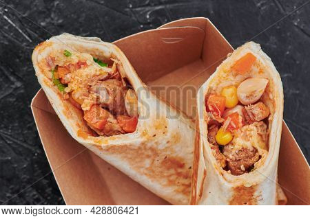 Mexican Burritos In A Craft Container On An Isolated Dark Background. Take Away Food. Photo For Menu