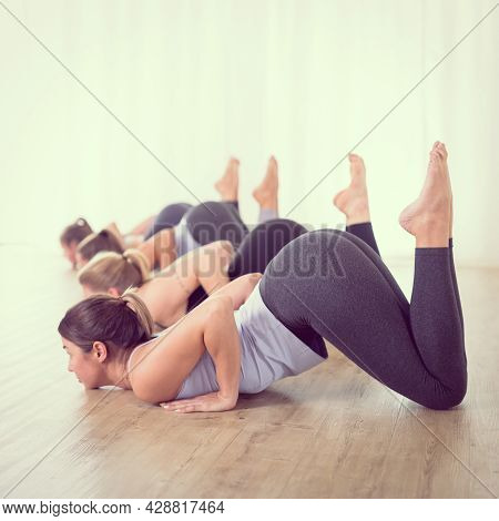 Group Of Young Sporty Sexy Women In Yoga Studio, Practicing Yoga Lesson With Instructor, Forming A L