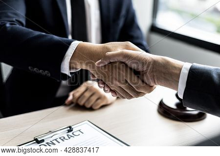 Lawyer And Client Shake Hands, Sign A Lawsuit For The Client, In Which The Client Has Filed A Lawsui