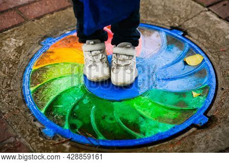 The Well, The Trapdoor On The Path, Is Painted With A Rainbow. Abstract Swirl Pattern Of Rainbow Col