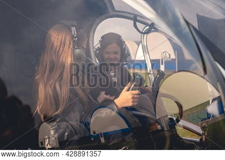 Cheerful Preteen Girls In Headsets Talking In Helicopter Cockpit