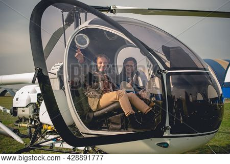 Cheerful Tween Girl Pointing To Sky From Helicopter Cockpit