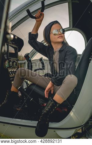 Tween Girl In Mirrored Sunglasses Sitting On Pilots Seat In Open Helicopter
