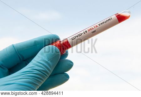 The nurce holding  tube of blood test with the label Covid-19 DELTA Variant.