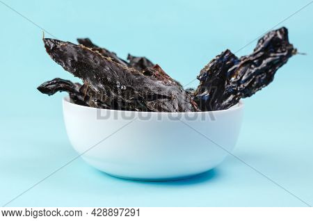 Training Treats For Pets On Blue Background. Natural Air Dried Dog Treats In A White Ceramic Bowl. T