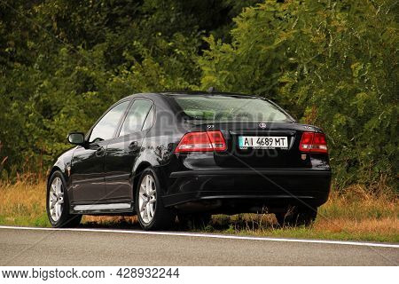Chernigov, Ukraine - July 24, 2021: Saab Car On The Road. Black Saab 9-3 Car On The Background Of Tr