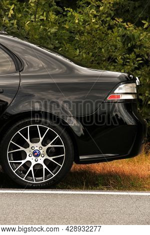 Chernigov, Ukraine - July 24, 2021: Saab Car On The Road. Black Saab 9-3 Car On The Background Of Tr