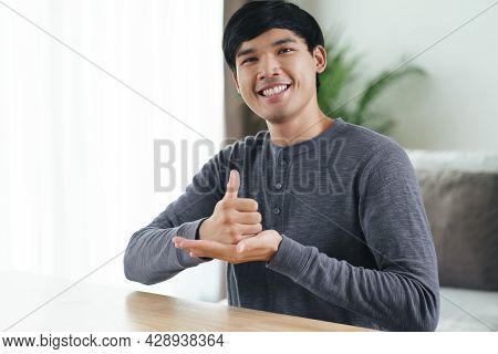 Young Asian Deaf Disabled Man Using Sign Language To Communicate With Other People.