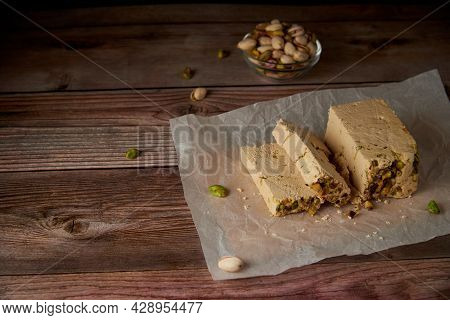 Organic Halva With Pistachios On A Wooden Surface. Traditional Middle Eastern Sweets. Jewish, turkis