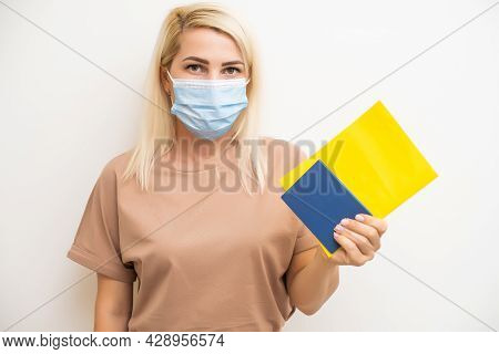 Woman With Medical Mask Holding Inernational Certificate Of The Vaccination. Adult Showing The Infor