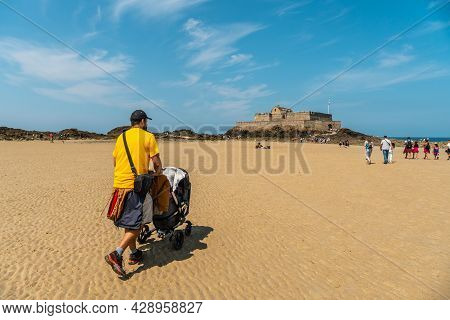 A Young Father Enjoying The Summer On The Grande Plage Du Sillon De Saint-malo In French Brittany, F