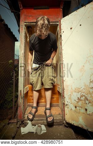 Man Leaving Wooden Toilet Latrine On Summer Cottage