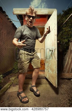 Man Leaving Wooden Toilet Latrine On Summer Cottage