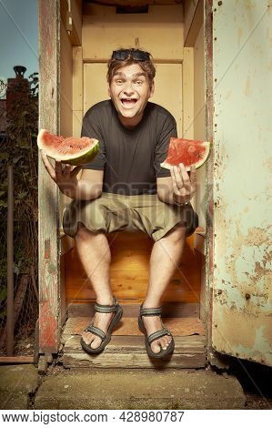 Man Sitting On Wooden Toilet Latrine And Eating Watermelon