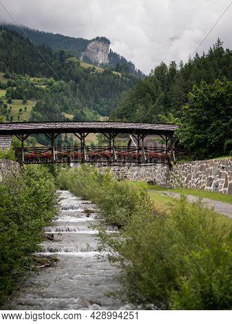 Old Wooden Bridge With Flowers In Matrei In Osttirol On A Cloudy Day In Summer