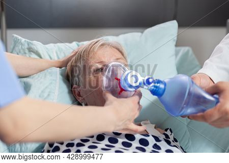 Close Up Shot Of Sick Senior Woman Inhale And Exhale With Help From Medical Staff Using Ambu Bag, Du