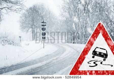 Snowy curvy road with traffic sign