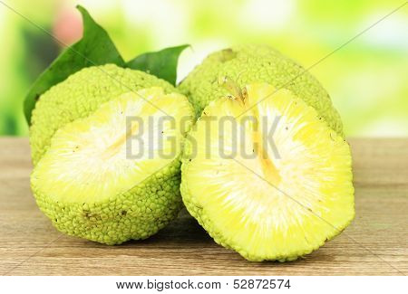 Osage Orange fruits (Maclura pomifera), on wooden table, on nature background