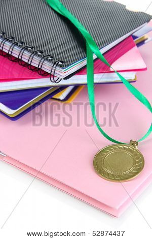 Medal for achievement in education and notebooks close up