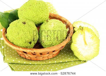 Osage Orange fruits (Maclura pomifera) in basket, isolated on white