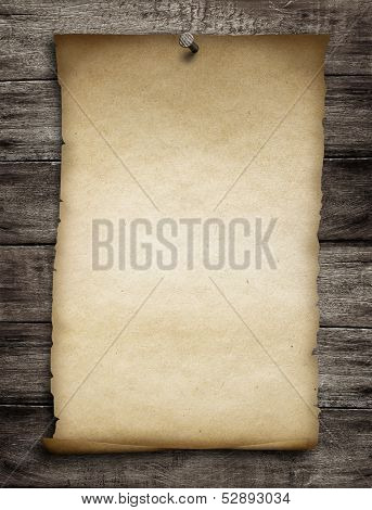 old wanted paper or parchment pinned by nail to grunge wooden background