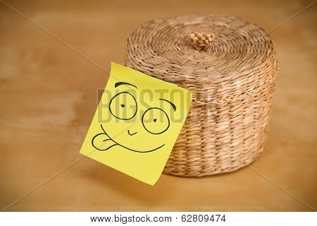 Drawn smiley face on a post-it note sticked on a jewelry box