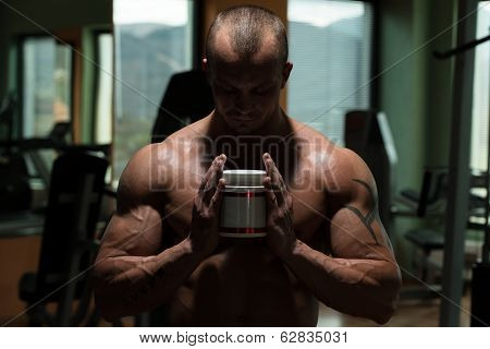 Bodybuilder Posing With Supplements For Copy Space