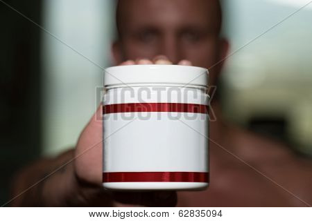 Bodybuilder Posing With Supplements For Copy Space
