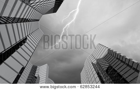 Bottom image of skyscraper with thunder lightning in sky