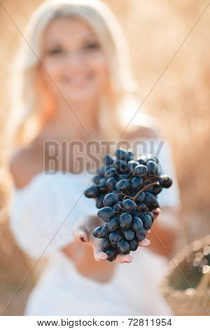 Portrait of a beautiful young woman with a basket of grapes