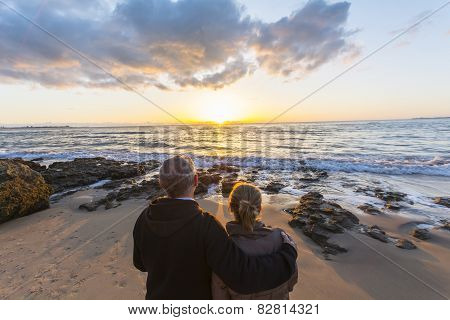Couple In Love Watching A Sunset On The Beach