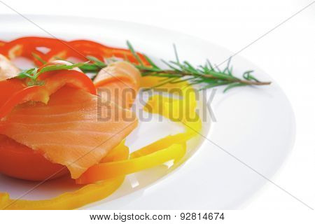 smoked salmon slices with vegetabls over white plate