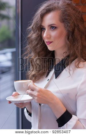 Beautiful Girl With Coffee In A White Shirt At The Window