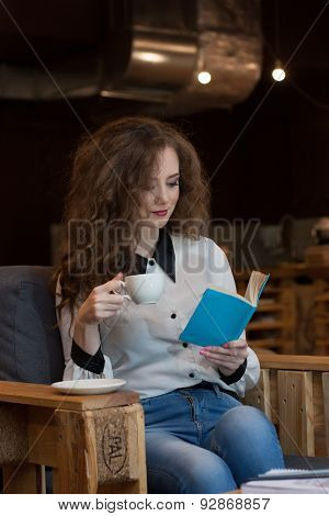 Beautiful Girl With Coffee Reading A Book In A Coffee Shop