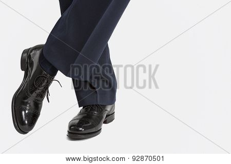 Closeup Of Male's Stylish Oxfrod Brogue Shoes Posing With Legs Crossed.
