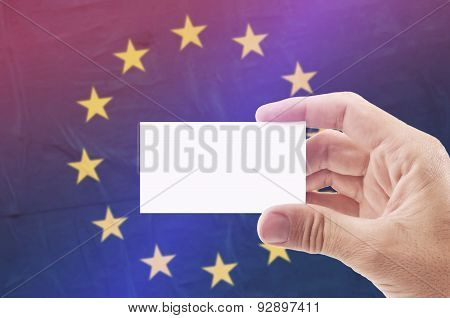 Man Holding Blank Business Card Against European Unionl Flag