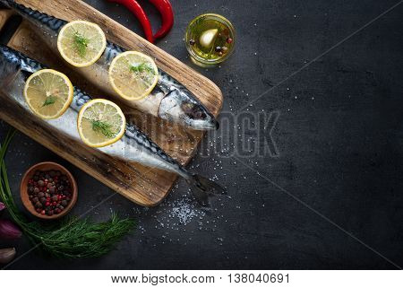 Fresh fish. Raw mackerel with salt lemon and spices on a dark background.