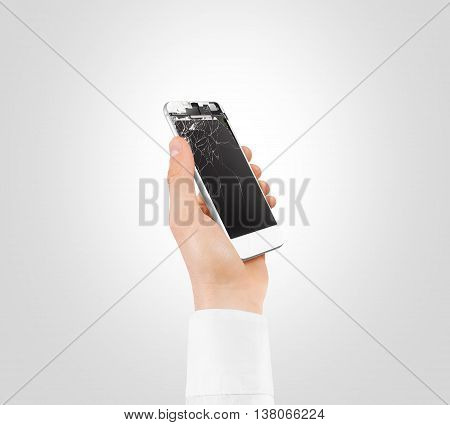 Hand holding white broken phone with smashed touch screen, cipping path. Arm hold cracked smartphone, isolated. Smart mobile cellphone display scratch. Telephone monitor problems, need repair.