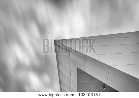 The conner of a giant building in the sky and motion cloud moving