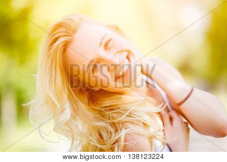 Blonde woman threw back her head. Image with lens flare effect