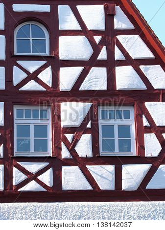 Gable and façade details of an old timber frame medieval house with white render and red beams in Nuermberg 2016